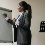 Confident businesswoman presenting ideas on a whiteboard during a seminar.
