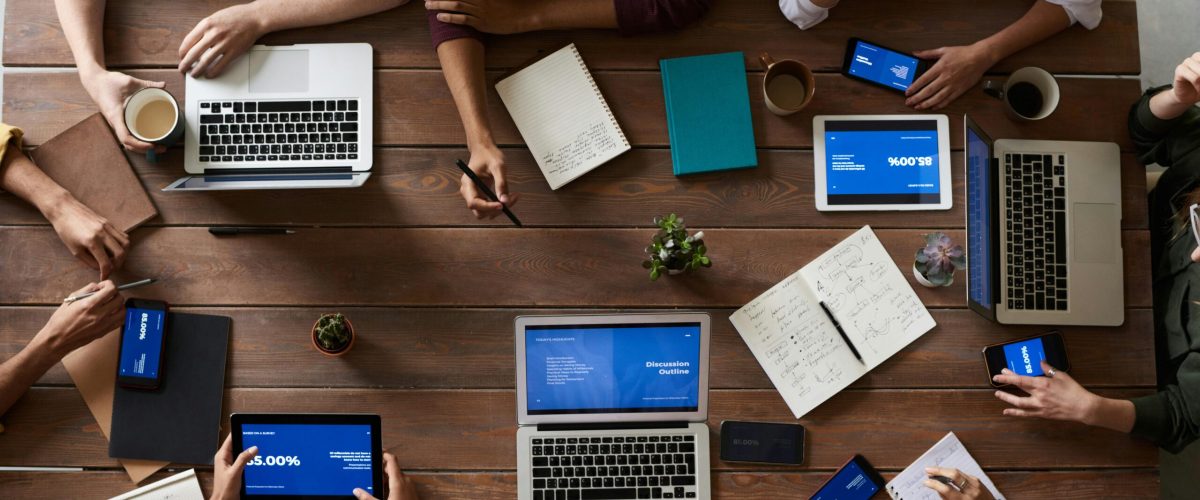 pexels-photo-3183150-3183150 Overhead view of a diverse team in a business meeting using laptops and tablets.